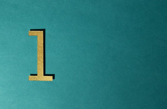 A gold number one on a teal background with ample copy space. by Miguel Á. Padriñán