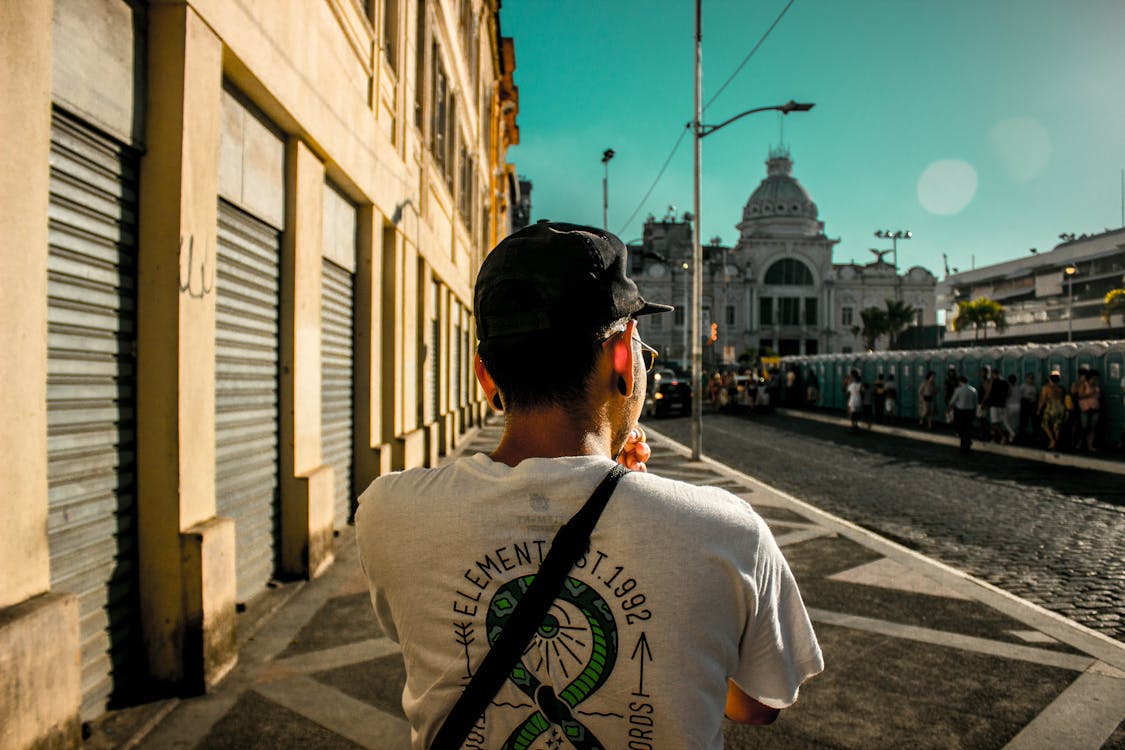 Back View Photo of Man Standing Beside Concrete Building