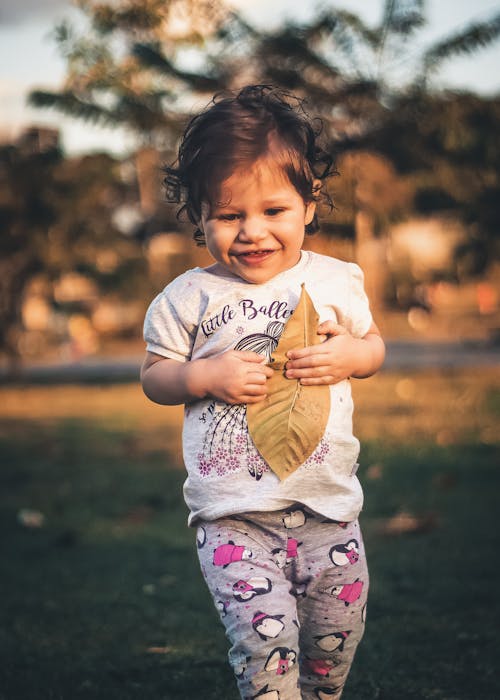 Girl Holding Brown Dry Leaf