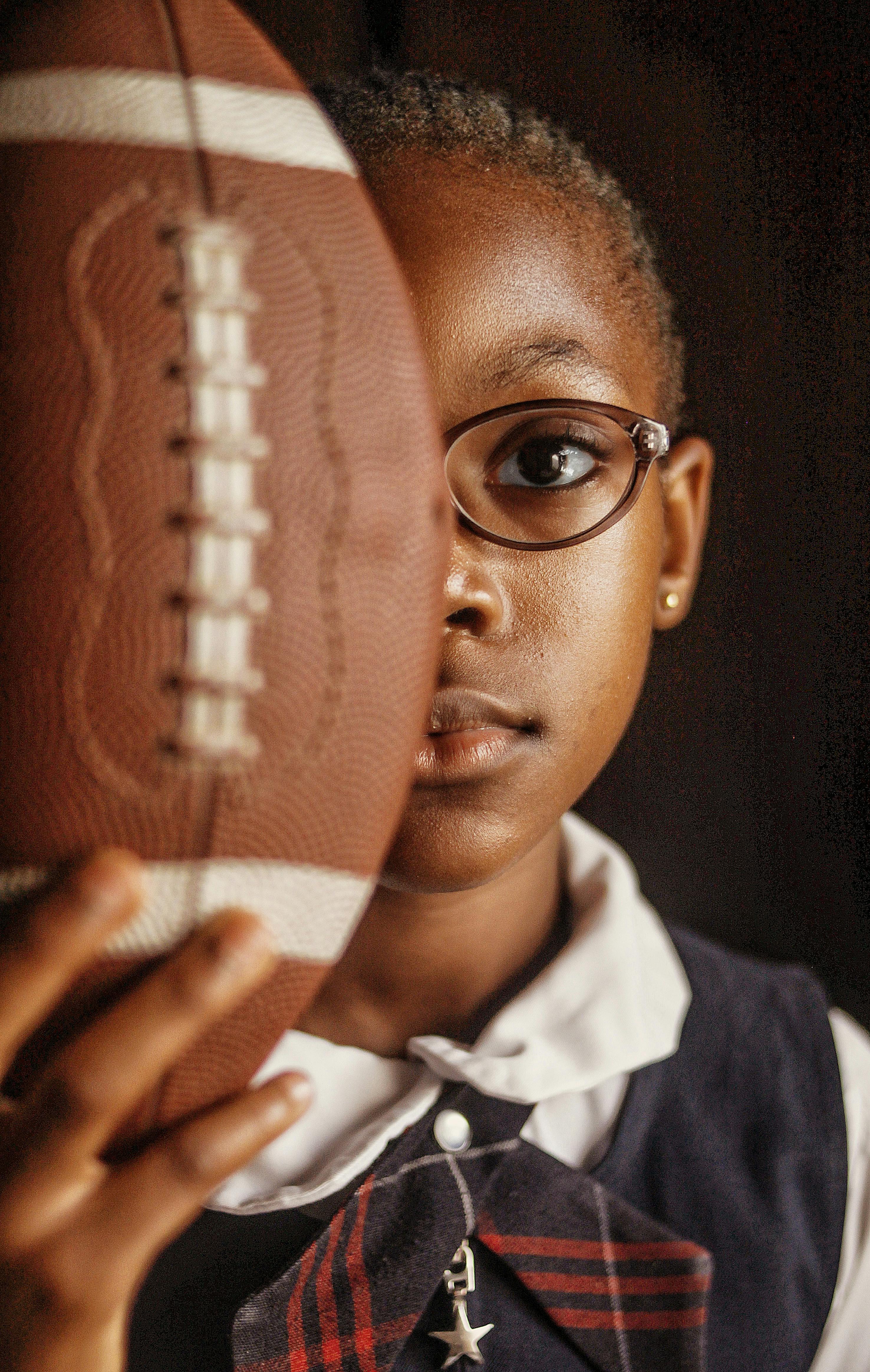 girl holding american football ball