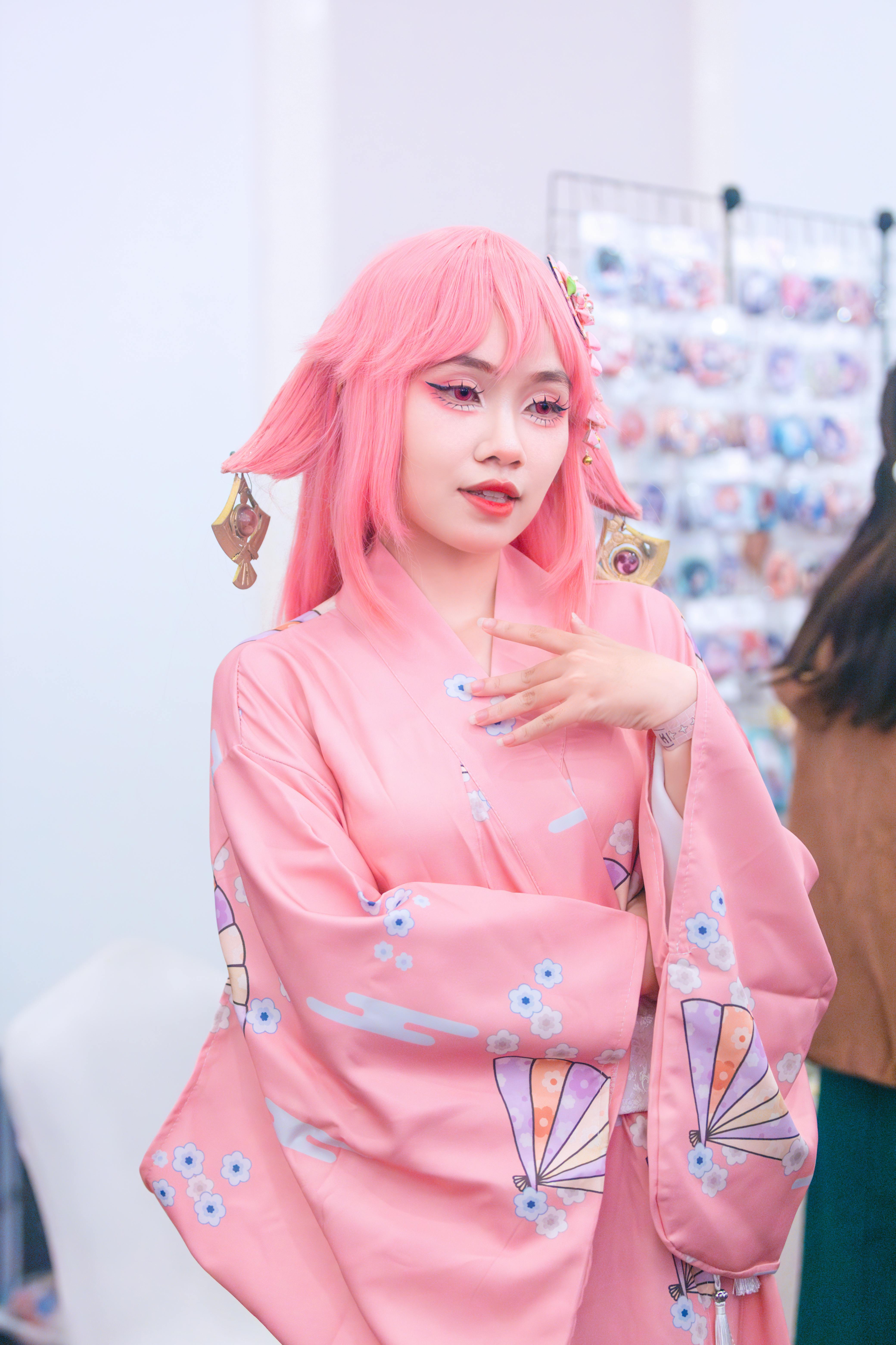 Beautiful cosplay portrait of a woman in a pink kimono with elaborate accessories.