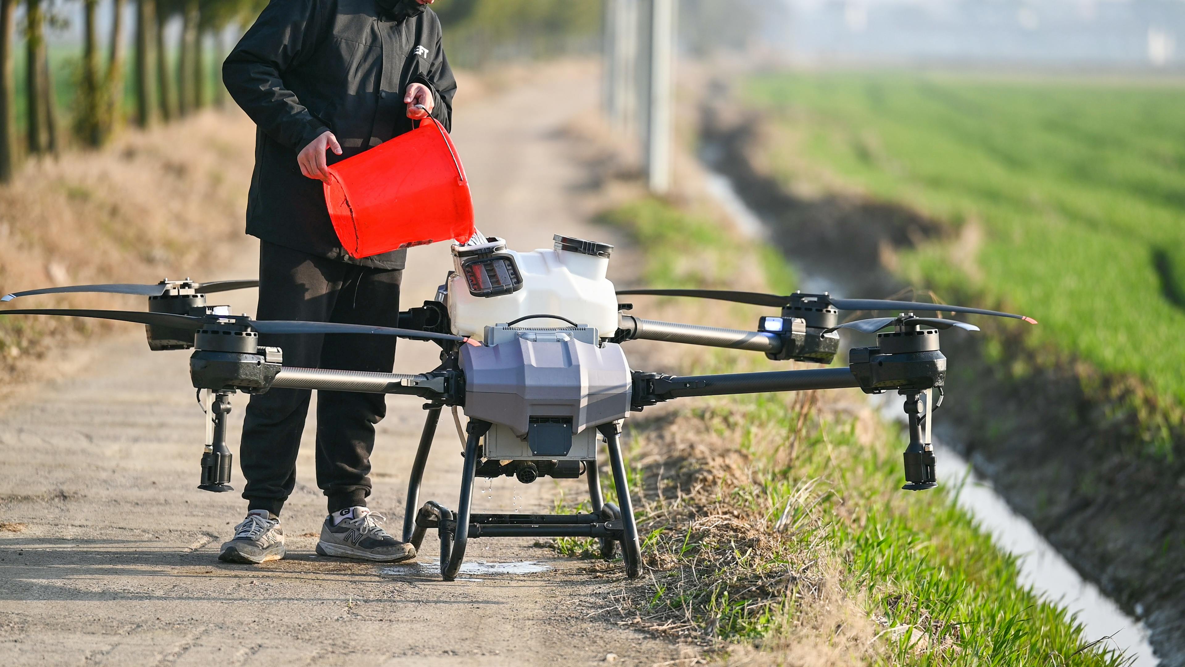 Person Filling Big Farming Drones with Liquid