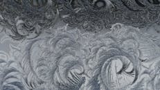 窗户上的霜冻图案特写，清晰地展示了自然的冰冻设计