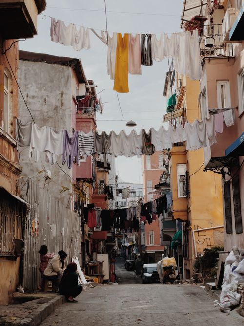 Free Colorful clothes drying on lines between apartment buildings in an urban alley. Stock Photo