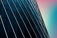 背景是色彩渐变的天空，现代玻璃建筑的立面景色引人注目