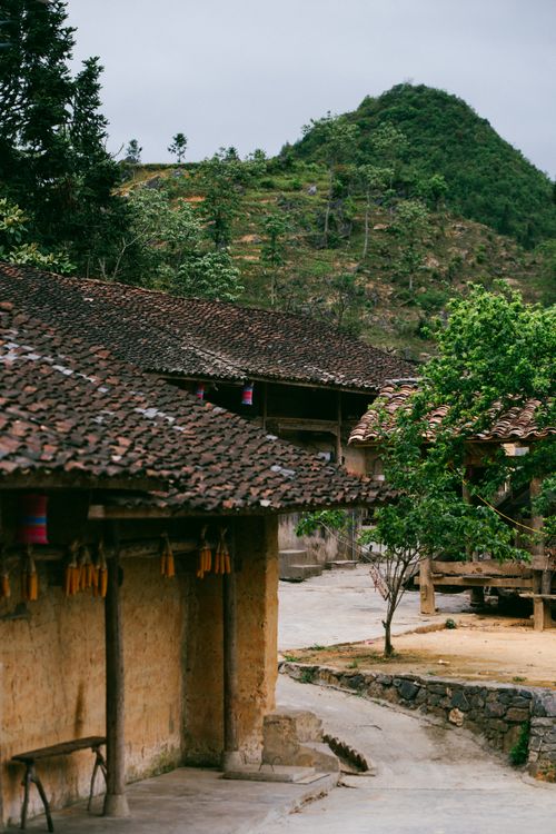 Free Idyllic village with rustic houses and lush mountains. Perfect for travel and nature enthusiasts. Stock Photo