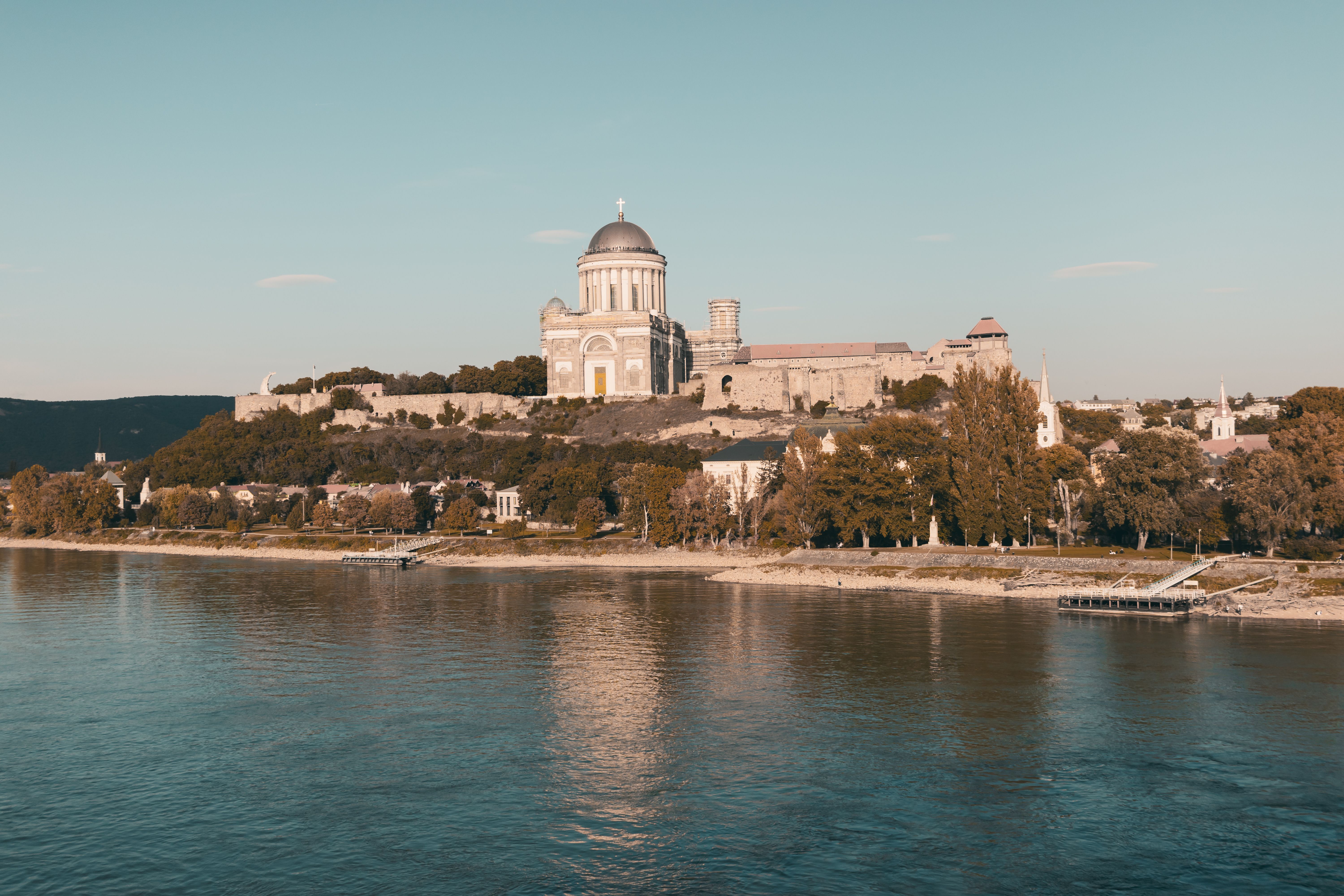 Fotomural Impresionante vista de la Basílica de Esztergom en Hungría, reflejándose en el río bajo un cielo despejado.