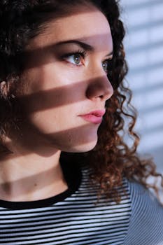 这是一幅女性的侧面肖像，光影交错于脸庞，营造出戏剧性的效果