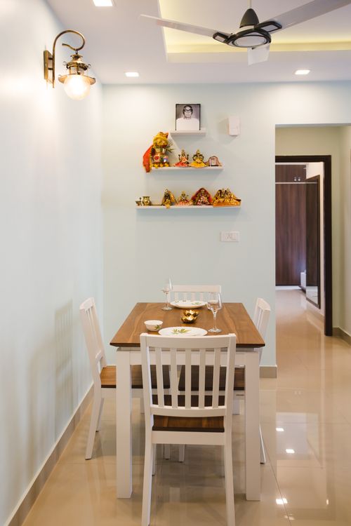 Free Stylish dining room interior with wooden table, ceiling fan, and elegant home decor in Bengaluru. Stock Photo