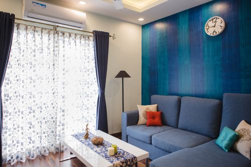 Free Elegant interior design featuring a modern blue sofa, clock, and decorative elements. Stock Photo