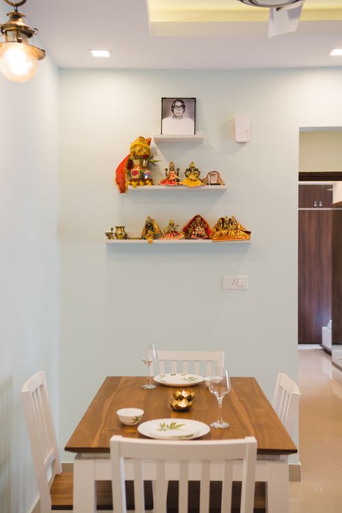 Free Warm dining space featuring a wooden table and artistic displays on shelves. Stock Photo