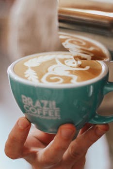 Close-up of intricate latte art in a teal mug from Brazil Coffee Roasters.