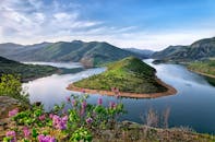 在晴朗的日子里，阿尔达河蜿蜒穿过郁郁葱葱的青山，景色美丽