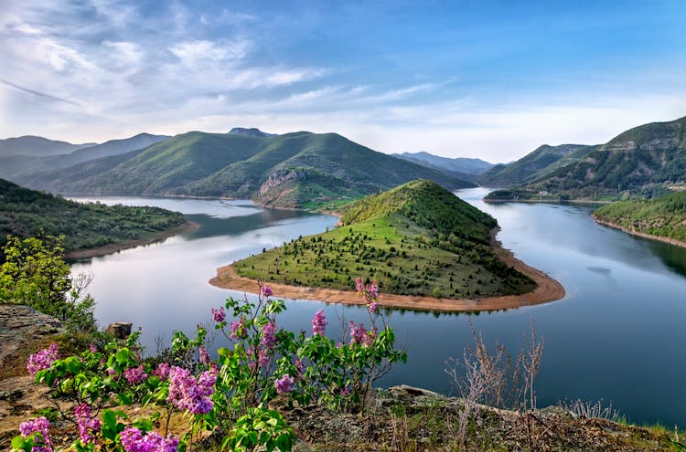 Green Mountain Surrounded By Body Of Water Photo