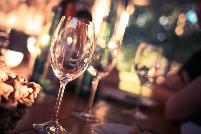 Wine glasses on a restaurant table with warm bokeh lights