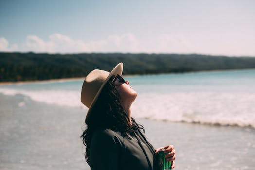 A woman enjoys the sunny beach at Bahia de Coson, Samaná, Dominican Republic, soaking up the summer vibes.