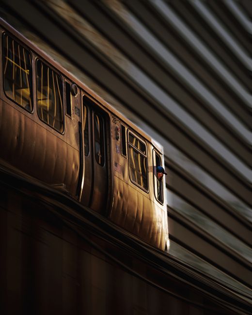 Long exposure capturing a moving subway train with a passenger peering outside, creating a dynamic urban scene.