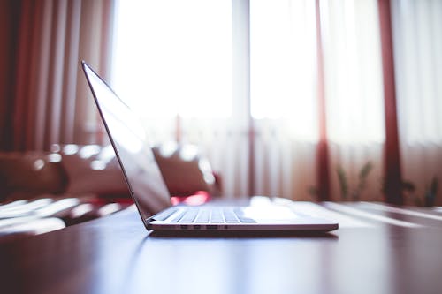 White Laptop Computer on Brown Wooden Table