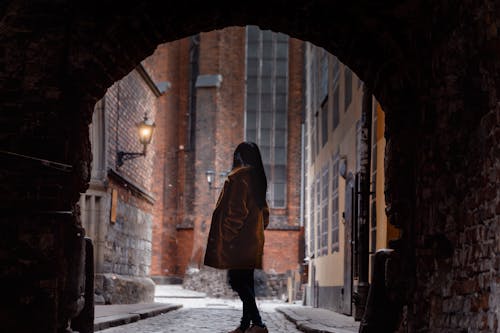 Woman Standing Inside Alley Tunnel