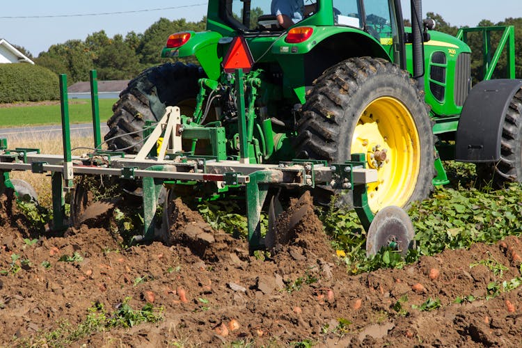 Tractor Plowing The Potato Field In Close Up