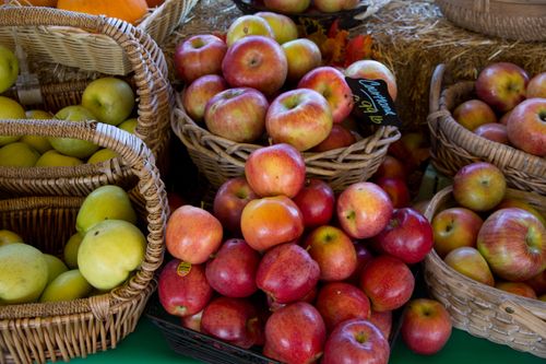 Free Close-up of vibrant apples in wicker baskets at a local market in fall. Stock Photo