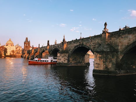 日落时分，乘船在伏尔塔瓦河上，欣赏查理大桥和布拉格标志性地标的风景