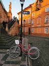 在风景如画的鹅卵石广场上，一辆老式自行车停在那里，沐浴着黄金时段的灯光，周围环绕着历史悠久的建筑