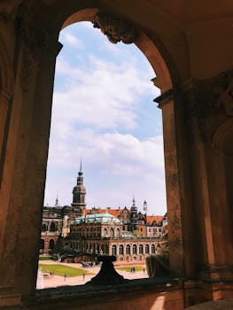 在晴朗的蓝天下，透过华丽的拱门，可以看见哥特式建筑和塔楼的历史框架