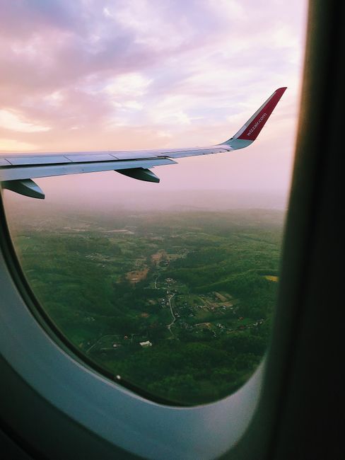 Peaceful aerial view of landscape through airplane window at sunset, perfect for travel themes.