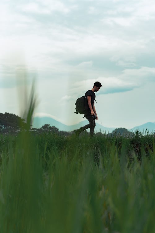 Man Walking on Grass Field