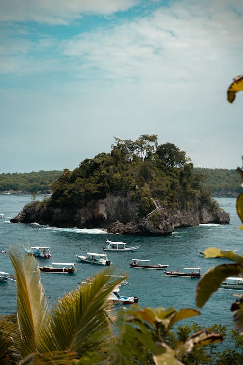 Several Boats Near Rock Islet at Sea