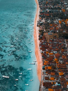 从空中俯瞰巴厘岛充满活力的海岸，清澈的蓝色海水与附近的度假村尽收眼底