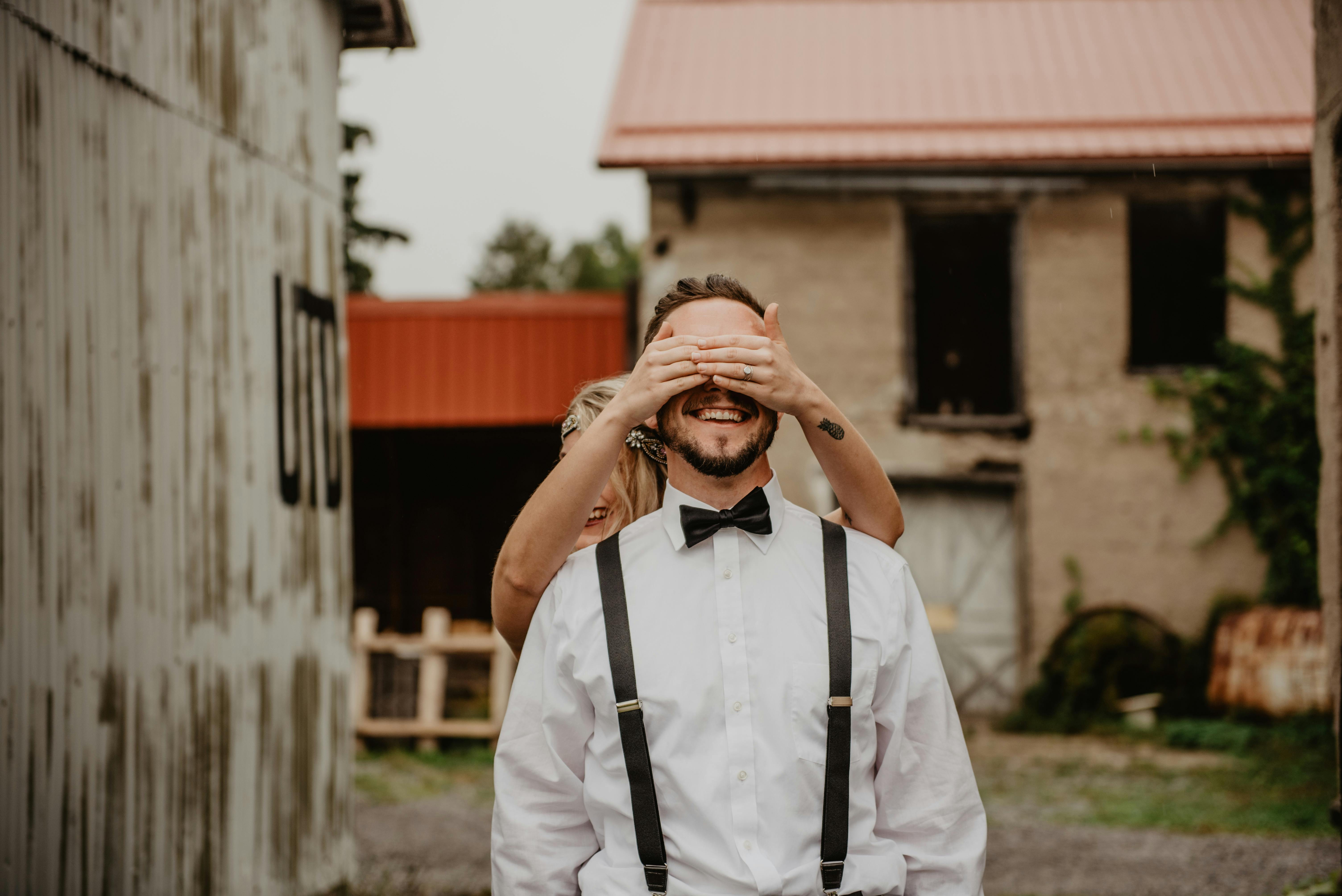 woman covering man s eyes