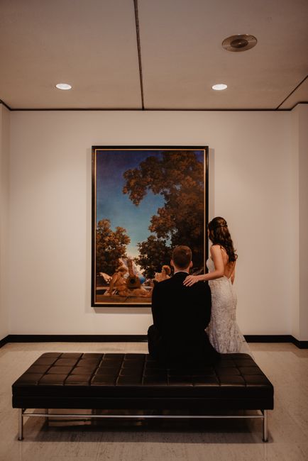 Elegant couple viewing a painting in a modern museum, capturing the essence of art appreciation.