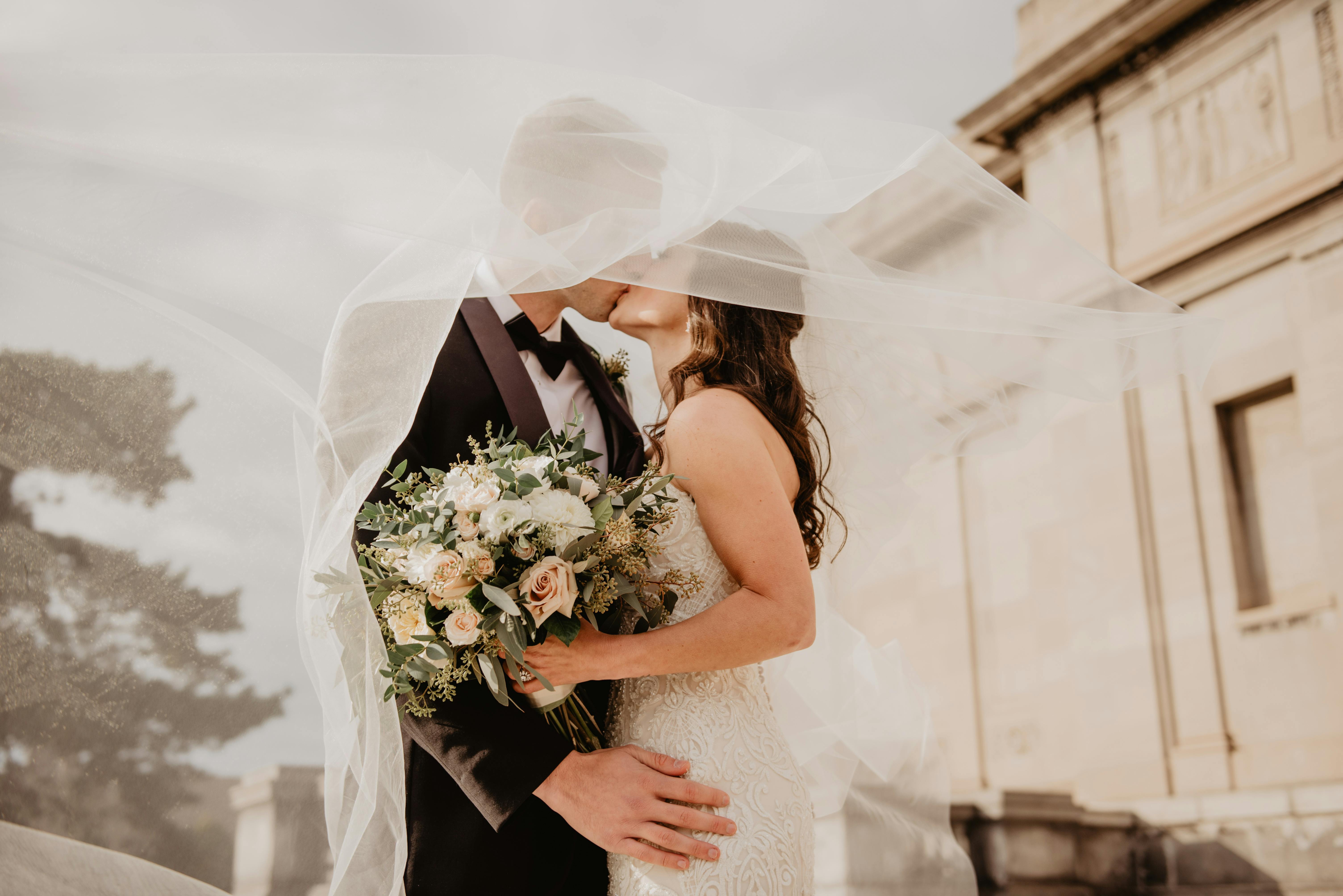 Man and woman kissing during their wedding ceremony. | Photo: Pexels