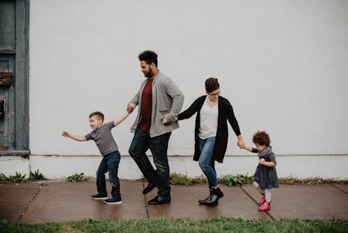 бесплатная Семья из четырех человек идет по улице Стоковое фото