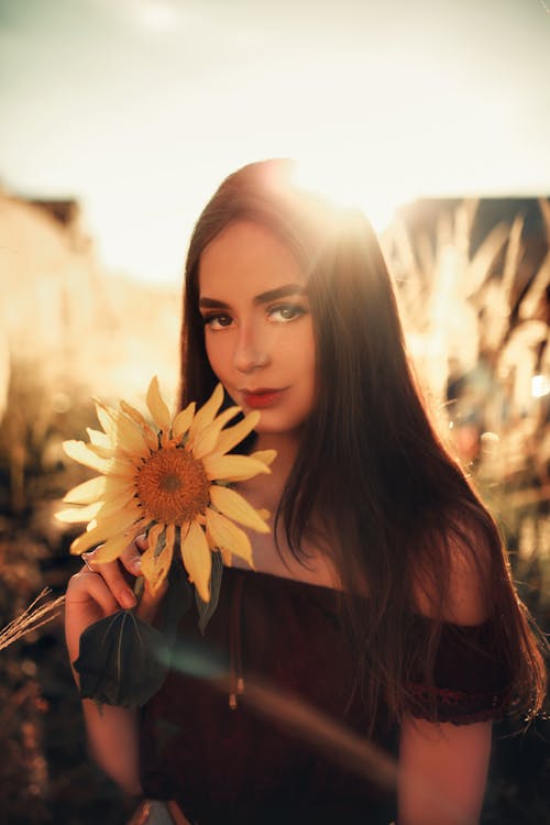 Woman Holding Sunflower in Close-up Photography