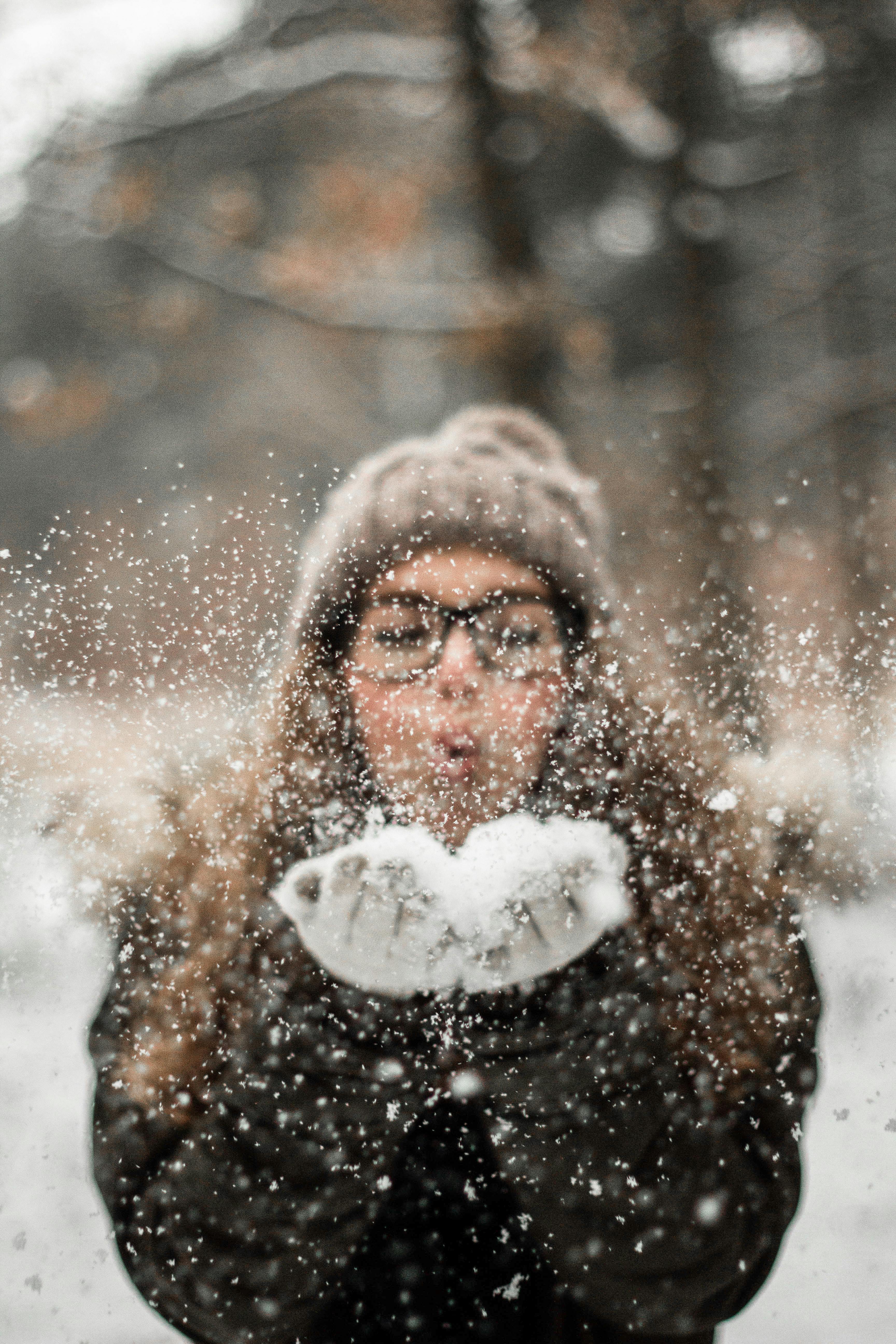 woman blowing snow outdoors