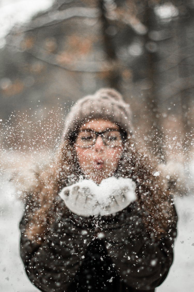 Woman Blowing Snow Outdoors