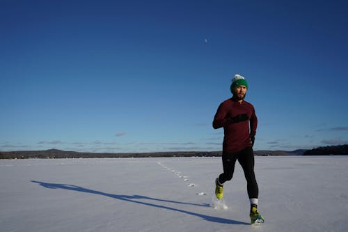 Homme Qui Court Sur Les Terres Couvertes De Glace