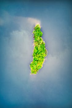 无人机镜头下，印度尼西亚一座充满活力的绿色岛屿，四周环绕着蓝色的海水