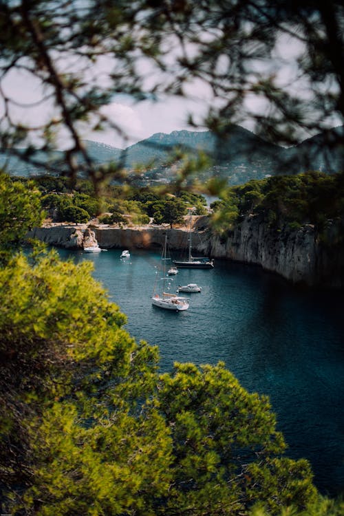 Boats on Water Near Cliff