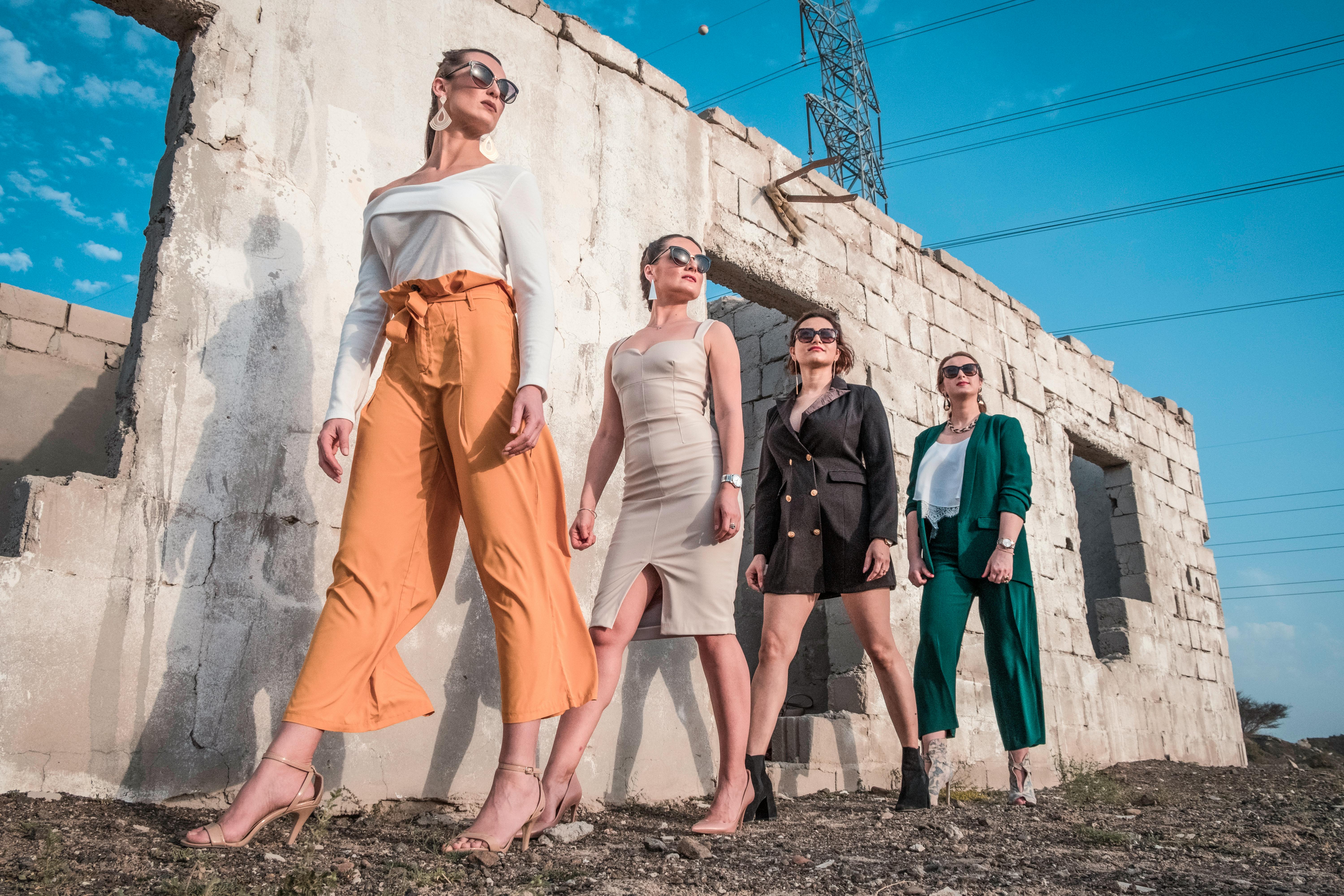 four women wearing casual attire near wall