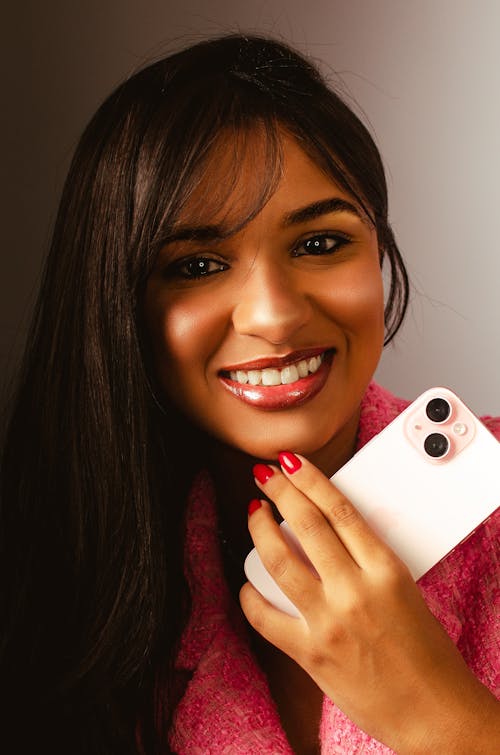 A woman holding up her phone and smiling