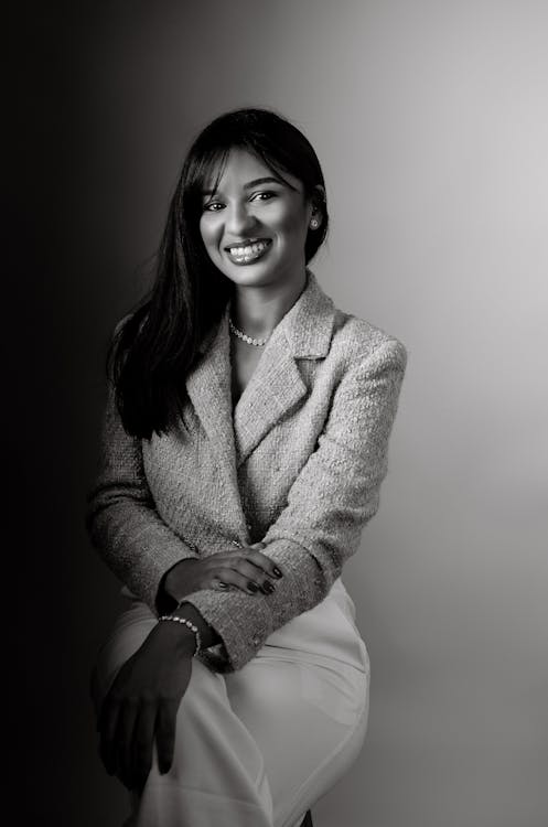 A woman in a suit sitting on a chair