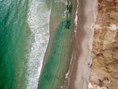 从空中俯瞰，彩虹海滩的海岸线令人惊叹，碧绿的海浪与独特的悬崖尽收眼底