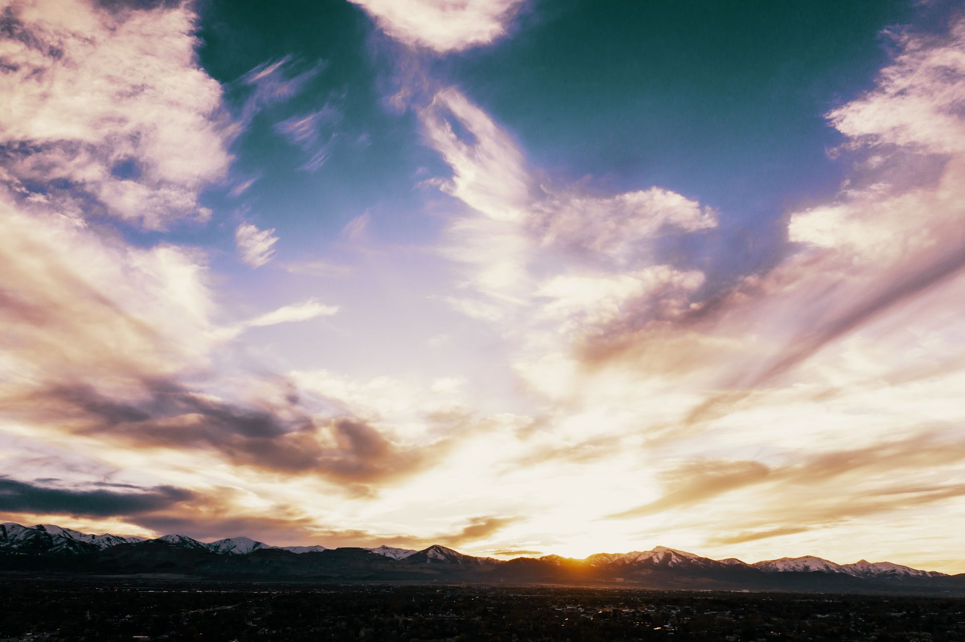 Breathtaking view of sunrise over mountain range in Herriman, Utah, showcasing vibrant sky colors.