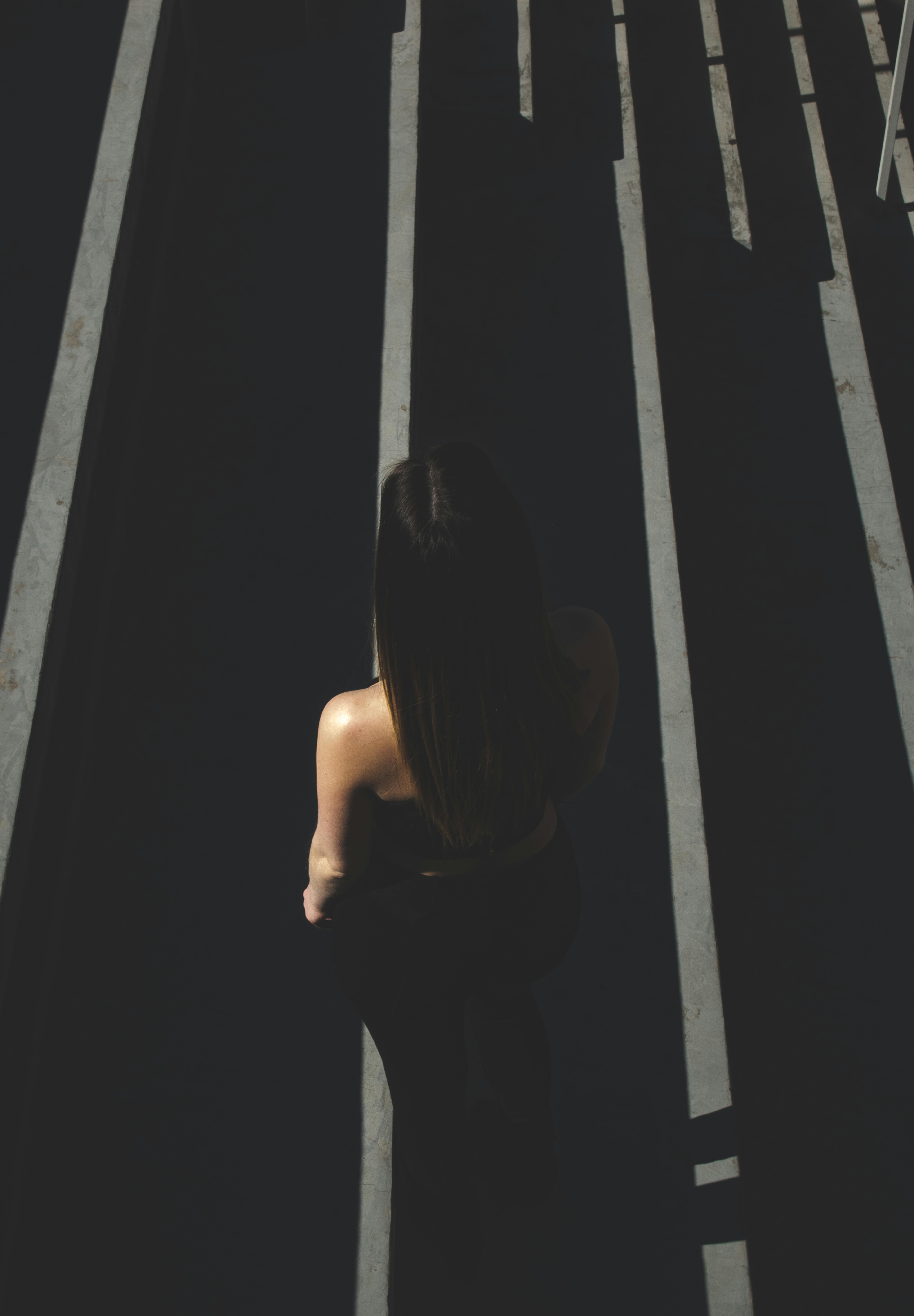 一名妇女的剪影走在户外戏剧性的阴影下，艺术而喜怒无常