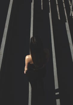 一名妇女的剪影走在户外戏剧性的阴影下，艺术而喜怒无常