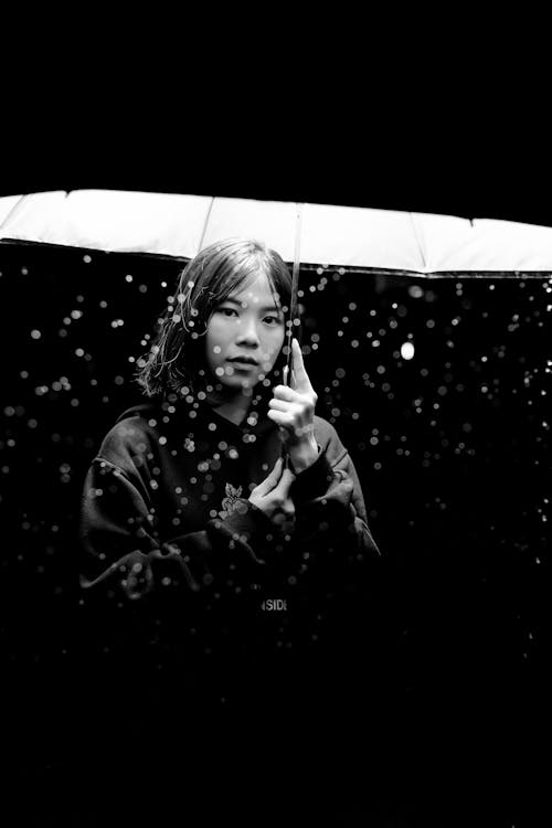 Фотография женщины, держащей зонтик в оттенках серого